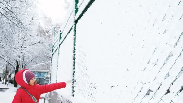 Kaukasische meisje hits de netto sneeuw op een basketbalveld, de sneeuw eraf valt het raster — Stockvideo