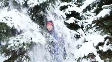 Kar ağaç dalları gülümseyen bir adam, yavaş düşüyor.