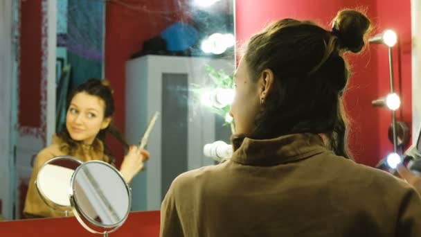 Mooi meisje krullen krullen een curling kleed in de kleedkamer, de kunstenaar bereidt zich voor op een prestaties of foto shoot — Stockvideo