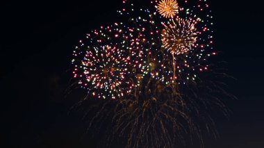 Şehrin gün tatil, üzerinde havai fişek büyük gece gökyüzü üzerinde havai fişek patlamaları. Odak dışında