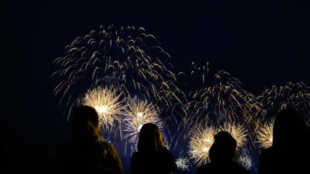 Una multitud de personas viendo un gran saludo brillante en el cielo nocturno, filmado en teléfonos inteligentes — Vídeo de stock