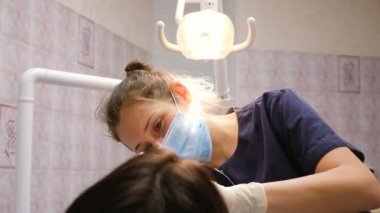 Hasta bir diş hekimi ile bir resepsiyonda. Genç kadın uzmanı diş istemciye davranır.