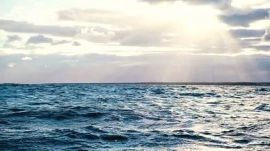 Dalgalar deniz günbatımı, ağır çekim, güneş ışığı çerçevede azgın. Dalgaların ve su sıçramalarına kıyı