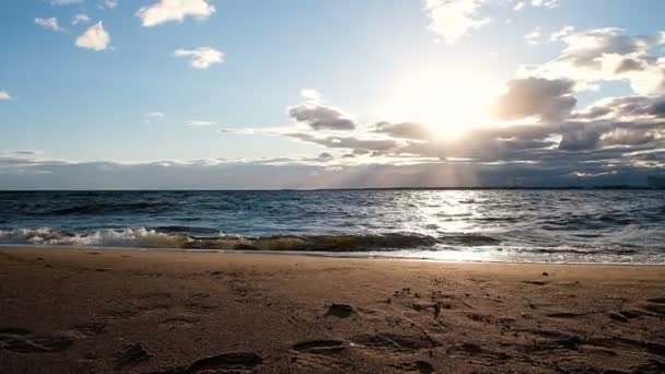 Movimento lento das ondas do mar na tempestade ao pôr-do-sol. Areia dourada ao sol — Vídeo de Stock