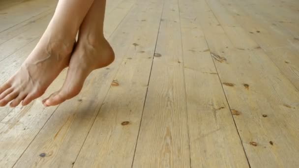 Chica balanceándose en un columpio en el apartamento loft. Las piernas desnudas de una mujer cuelgan sobre el suelo, el descanso y la relajación — Vídeo de stock