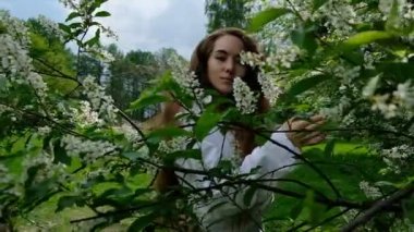 Çiçek açması kuş kiraz, ağır çekim kamera poz seksi Avrupa kız modeli. Park, ağır çekim uzun gür saçlı bir kadın fotoğrafı