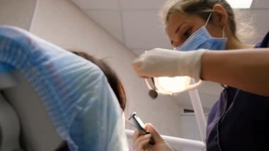 Genç kadın diş hekimi tedavi ve diş hastaya sondaj. Stomatologist Doktor Resepsiyon üzerinde