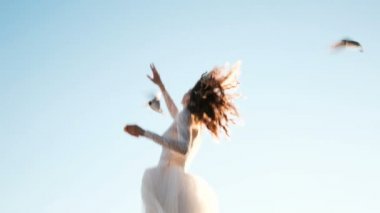 Bir gelinlik Avrupa Genç kadın martılar doğada besleniyor. Mutlu nevet ekmek kuşlarla beslenir