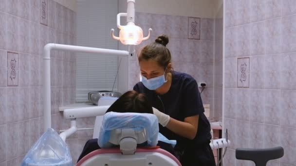 年轻妇女牙医对待患者牙。在 stomatologist 医生的招待会上 — 图库视频影像