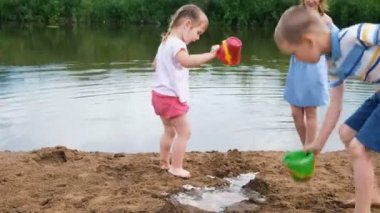 Küçük çocuklar yaz aylarında nehir oynamak. Çocuklara anne görünüyor.