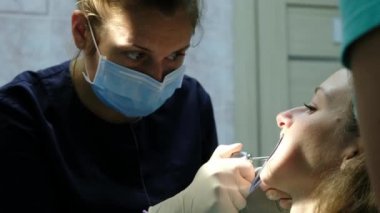 Diş hekimi kurur ve anten sistemi yakın çekim yüklemeden önce dişleri temizler. Ortodontist için ziyaret edin