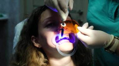 Diş hekimi asistanı hastalarda diş polimerizasyon ultraviyole lambalı diş parlar. İçin stomatologist ziyaret edin
