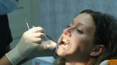 Diş hekimi, anten sistemi kurulumu ve maloklüzyon düzeltilmesi için ziyaret edin. Ortodontist yüklü ayraçları metninizi düzeltme ve diş aynaya görünüyor yakın.