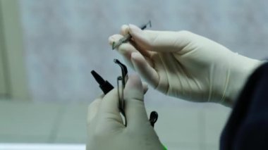 Eldivenli diş hekimi diş yakın çekim bir köşeli ayraç sistemini kurmak için Araçlar hazırlar.