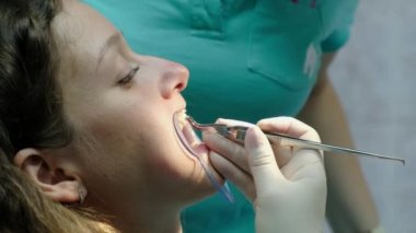 Diş hekimi, anten sistemi kurulumu ve maloklüzyon düzeltilmesi için ziyaret edin. Ortodontist yükler ve diş yakın çekim üzerinde parantez tutkallar.