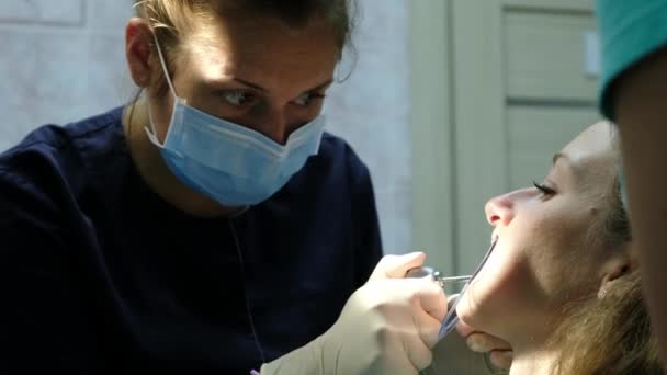 El dentista seca y limpia los dientes antes de instalar el primer plano del sistema de soporte. Visita al ortodoncista — Vídeo de stock