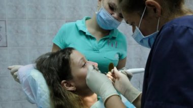 Dişçiye ziyaret edin. Ortodontist doktor asistanı ile demir diş telleri kadar bir diş fiksatör olan bir kadın için ayarlar