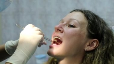 Dişçiye ziyaret edin. Ortodontist Aydınger kağıdı hastanın ağzından kaldırır.