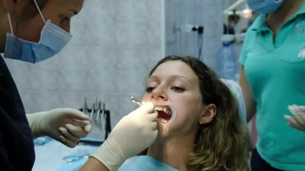 Instalación de tirantes metálicos de cerca, visita al dentista. Ortodoncista lava la solución de los dientes — Vídeo de stock