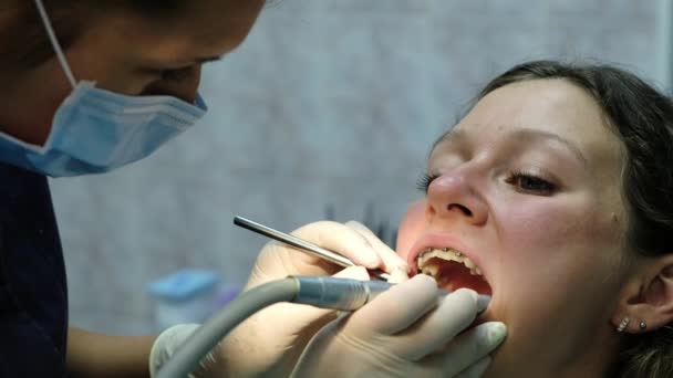 Visita al dentista. Taladros ortodoncistas y corrige el sello del parche . — Vídeos de Stock