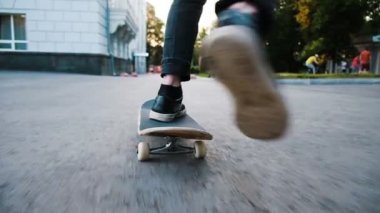 Adam bir kaykay üzerinde bir ollie flip - hüner kickflip sıçrama bir engel yakın kadar ağır çekim bir yönüyle üzerinde gerçekleştirir.