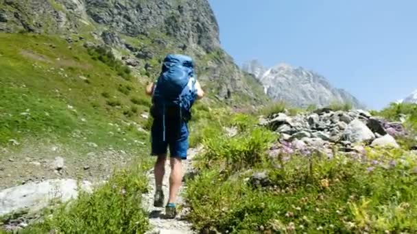 Man climbs uphill and raises his hands up after climbing in a hiking trip, a beautiful view opens up. The concept of victory and success, the achievement of the goal — Stock Video