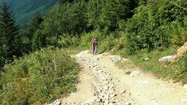 Unavená žena turista v trekingové boty, batoh stoupá do kopce, pomalý pohyb — Stock video