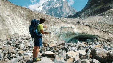 Uzun yürüyüşe çıkan kimse seyahat rehberi bir adam yol haritası üzerindeki çalışmalar ve dağ yürüyüşü, kamera hareketi giden yolu gösterir.