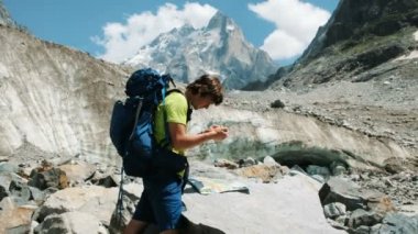 Turist adam üstünde belgili tanımlık harita ve telefon Gps, rota keşfetmek bir sırt çantası ile bir harita ekler ve dağ zammı bir rotada devam ediyor