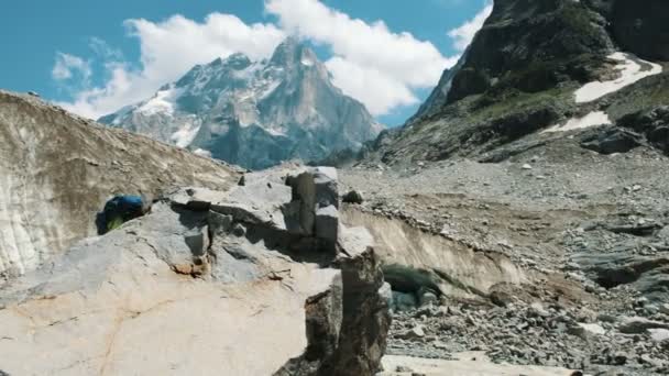 人与背包游人攀登在岩石和举起他的手在山山在竞选反对山风景 胜利与成功的理念 实现目标 — 图库视频影像