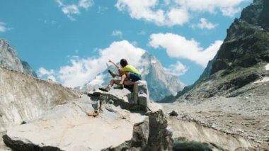 Birkaç turist kayanın üzerinde oturmak ve bir kağıt harita çalışma, bir rota bir dağ yürüyüş içinde.