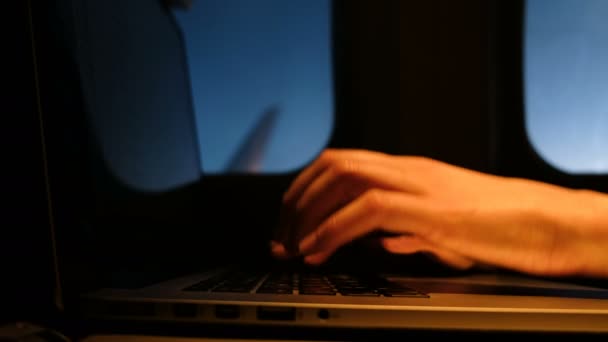 自由职业者的女人手打字在笔记本电脑键盘在晚上在飞机上的舷窗窗口的背景和清洁天空特写 — 图库视频影像