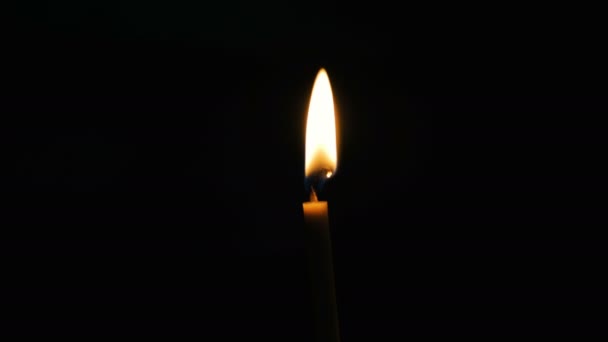 Chama na vela de cera queima e brilha no antigo templo escuro ortodoxo — Vídeo de Stock