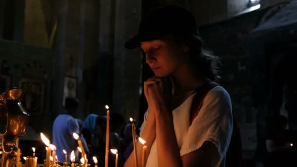 Женщина-туристка молится в православном католическом древнем храме — стоковое видео