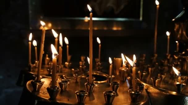 Wax candles burn and stand on the sand in the censer of the Orthodox ancient temple, slow motion — Stock Video