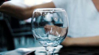 Kadın dökülen bir restoranda bir cam bir şişe soda limonata yakın çekim. Ağır çekim.