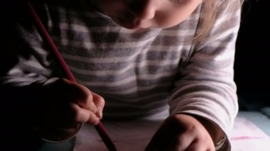 Küçük kız bir yaprak kağıda, başındaki atar bir kalem - ana sayfa eğitim.