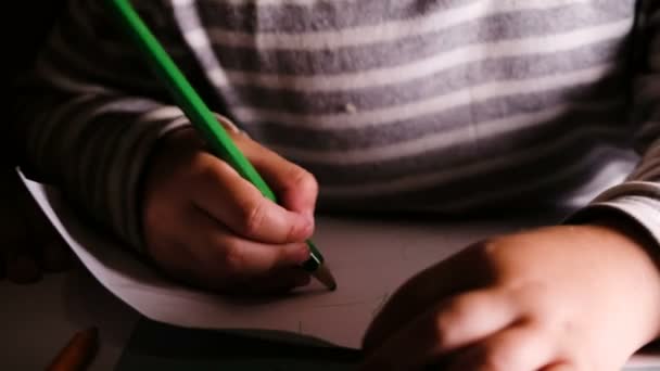 Criança pequena desenha lápis verde em uma folha de papel close-up — Vídeo de Stock