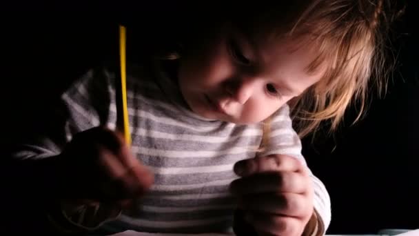 Niña preescolar dibuja un lápiz en una hoja de papel, primer plano — Vídeos de Stock