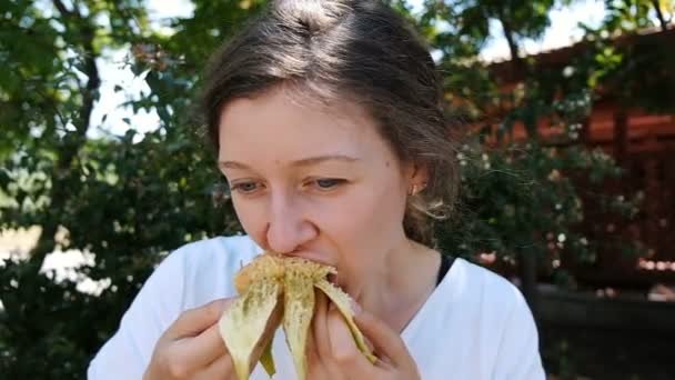 Hermosa joven mordiendo y comiendo higos maduros en un parque de verano de cerca, cámara lenta . — Vídeos de Stock