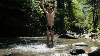 Adam bir dağ nehir yaz aylarında su sıçramalarına, adam suda duruyor ve bir çocuk gibi yavaş hareket sevinir