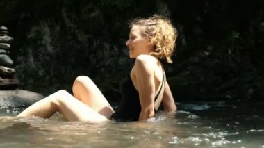 Genç kadın duygusal soğuktan çığlığı bir dağ soğuk nehirde temperli bir mayo