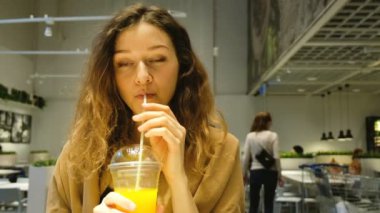 Genç kadın bir kafede içecekler taze sıkılmış suyu