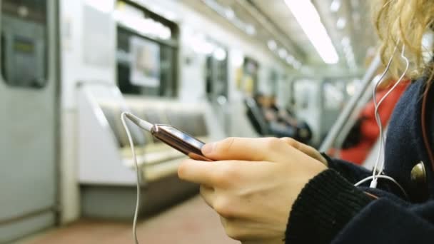 La mujer usa un teléfono en el primer plano del metro — Vídeos de Stock