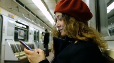 Kadın bir smartphone metroda kullanır.