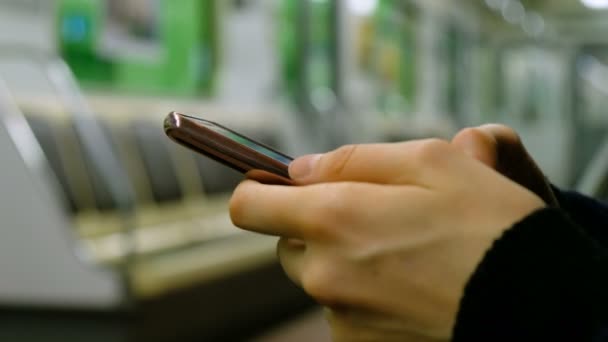 Ragazza sta usando uno smartphone in un primo piano della metropolitana — Video Stock