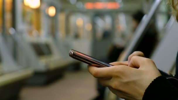 Meisje met een smartphone in een metro-close-up — Stockvideo