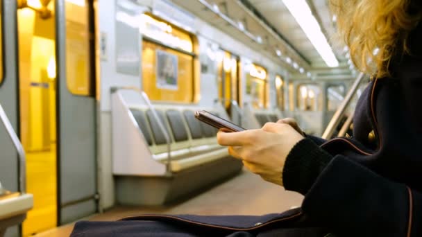 Mujer utiliza un teléfono inteligente en el primer plano del metro — Vídeo de stock
