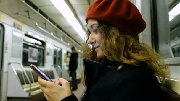 Mujer utiliza un teléfono inteligente en el metro — Vídeos de Stock