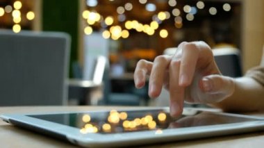 Kadın el üzerinde arka plan bulanık, bir kafede bir tablet bilgisayar pc kullanan yakın çekim